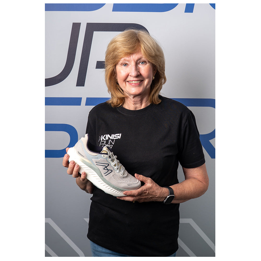 Photograph of Carole at Kinisi Run Hub holding a running shoe.