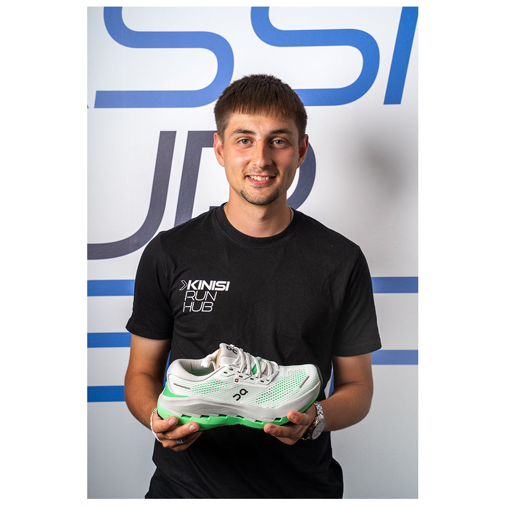 Photograph of Harrison at Kinisi Run Hub holding a running shoe.