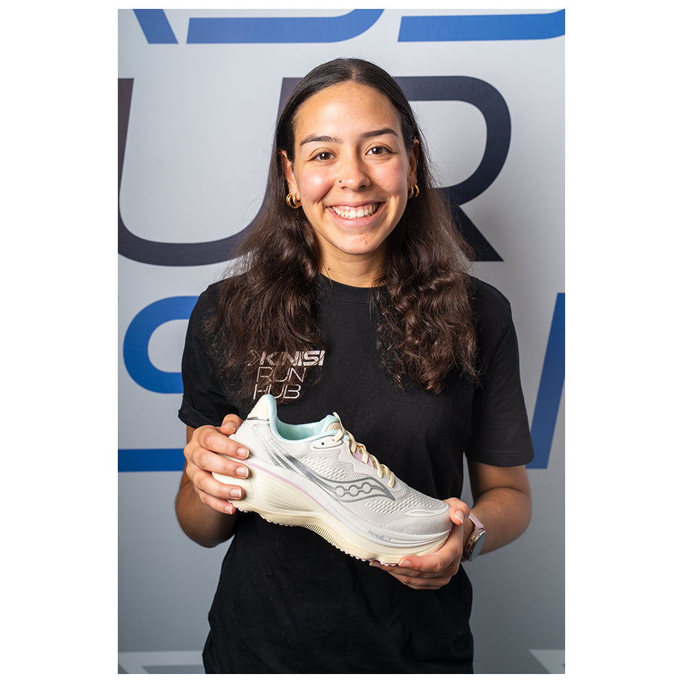 Photograph of Megan at Kinisi Run Hub holding a running shoe.