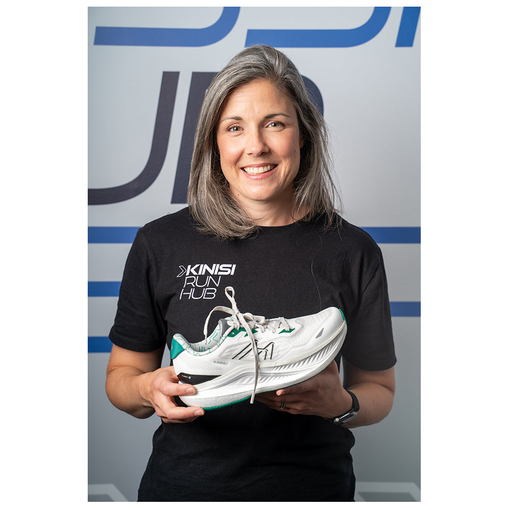 Photograph of Nancy at Kinisi Run Hub holding a running shoe.