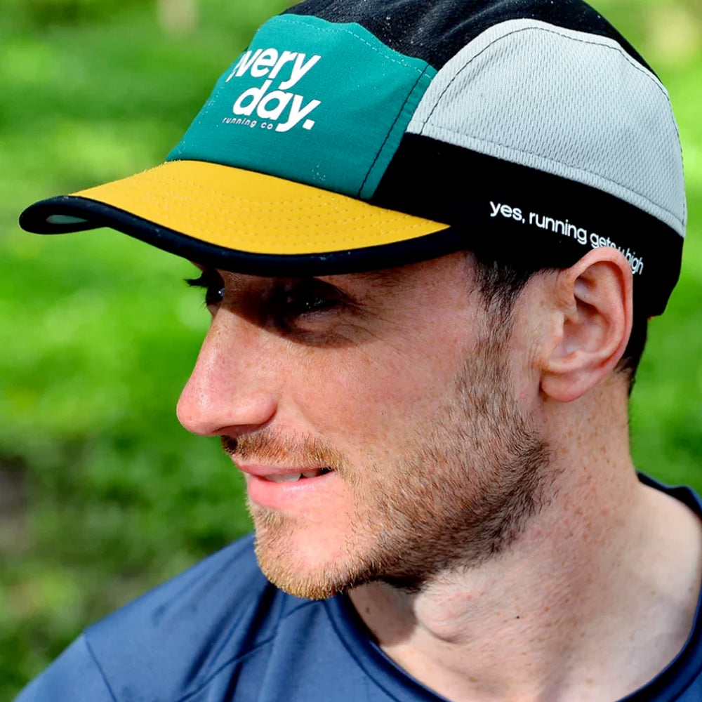 Image of a man wearing an Everyday Running Co cap in green, yellow, white and black block colouring