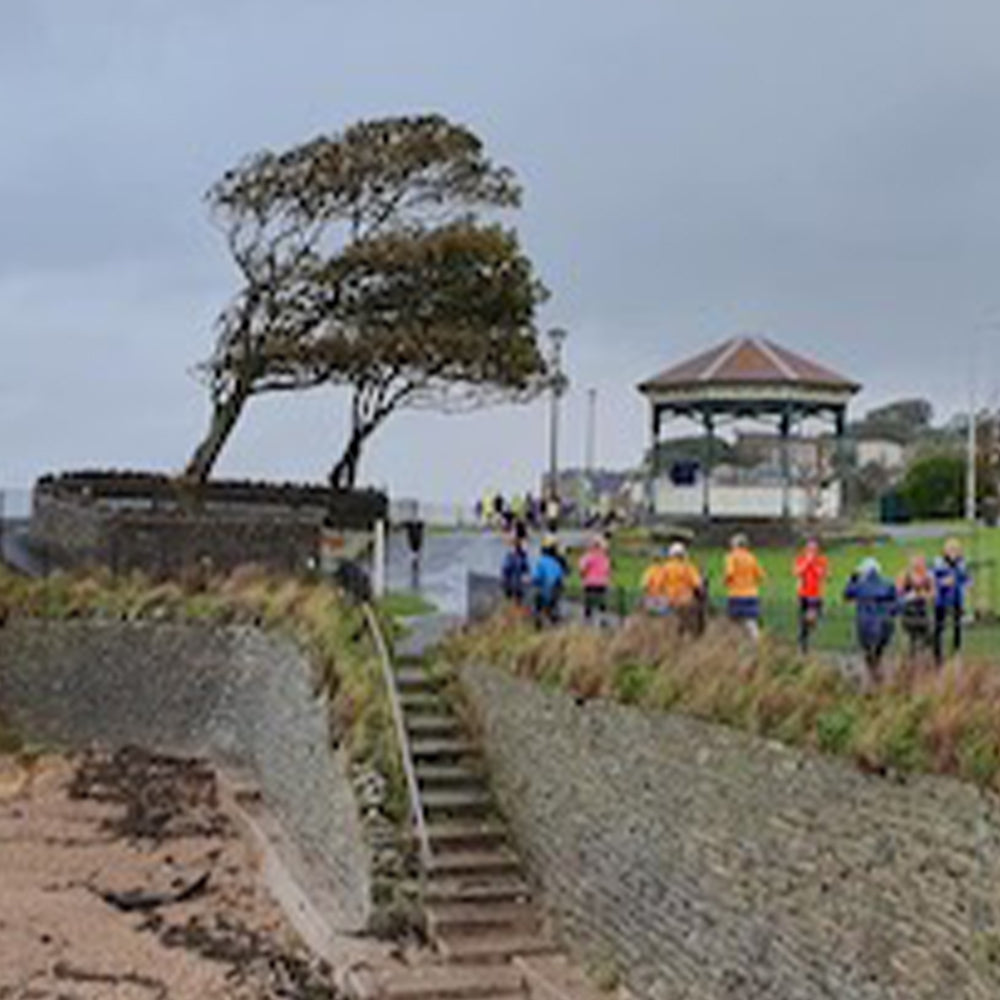Photograph of people at Clevedon Salthouse Parkrun running along a path by the beach