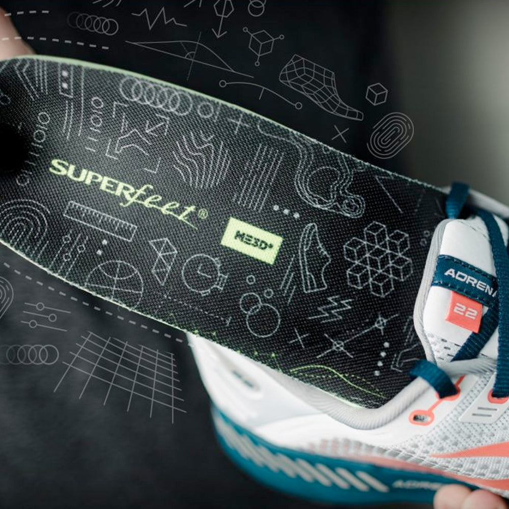 Image of a Superfeet insole being inserted into a running shoe