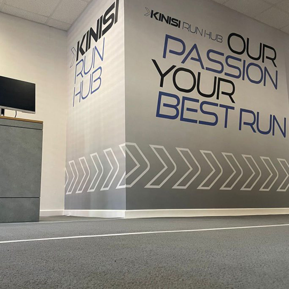 Photograph of inside Kinisi Run Hub, with the Kinisi Run Hub logo on the wall with the tagline 'our passion your best run'