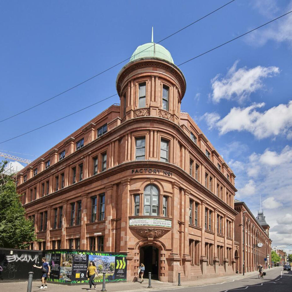 Image of the Kinisi brick building with a green dome under a blue sky