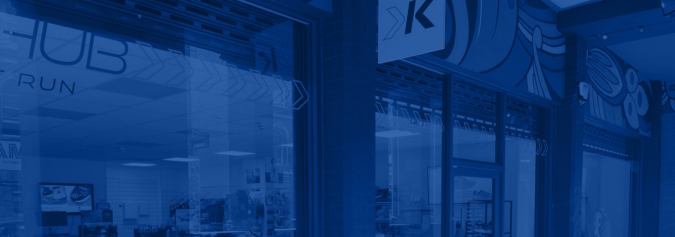 Photo of the exterior of the Kinisi Run Hub store, with a blue overlay