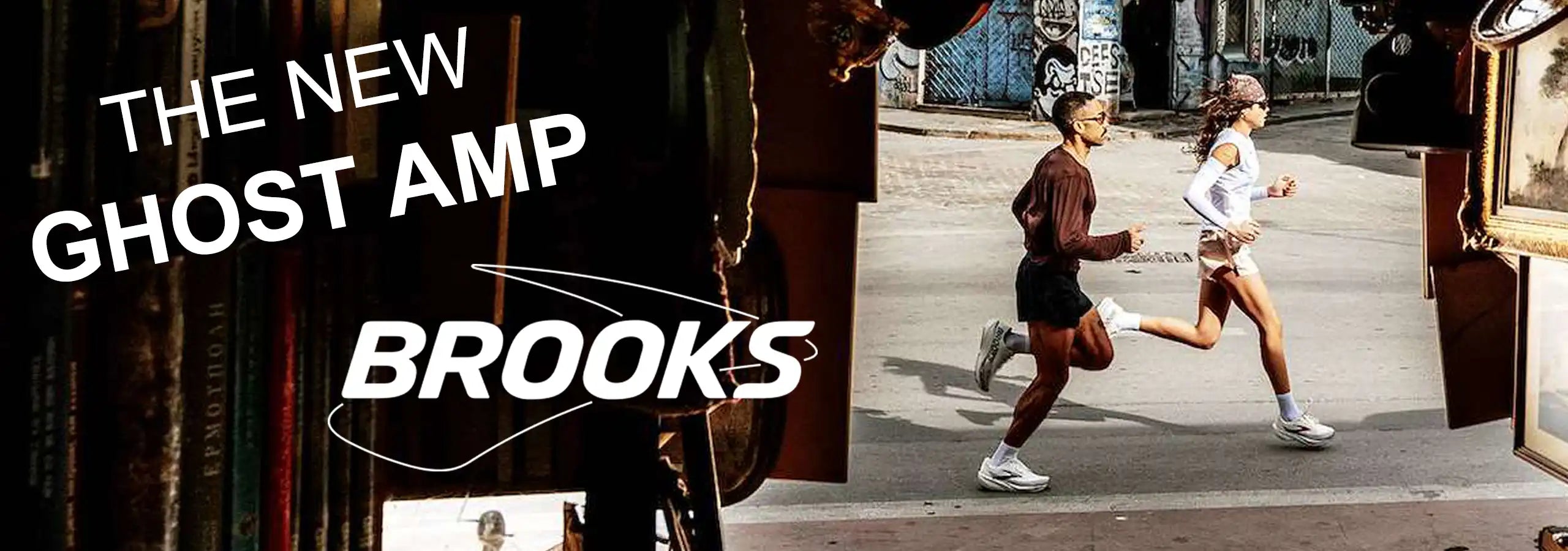 Brooks Ghost Amp running apparel promotional graphic with two runners in an urban street setting and large text reading 'THE NEW GHOST AMP BROOKS'.