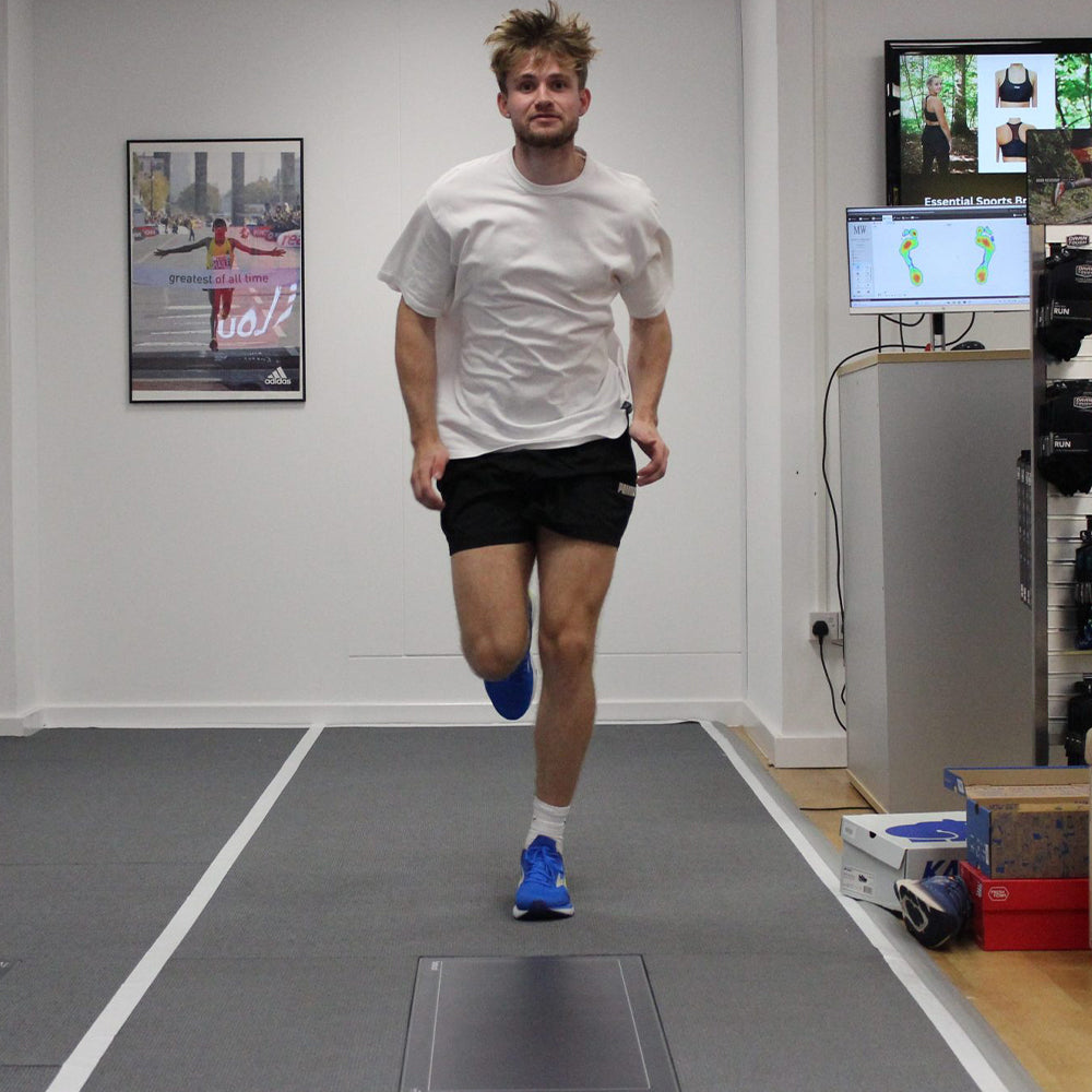 Photo of a customer running along the movement analysis track and pressure plates as part of Gait Analysis at Kinisi Run Hub Bristol