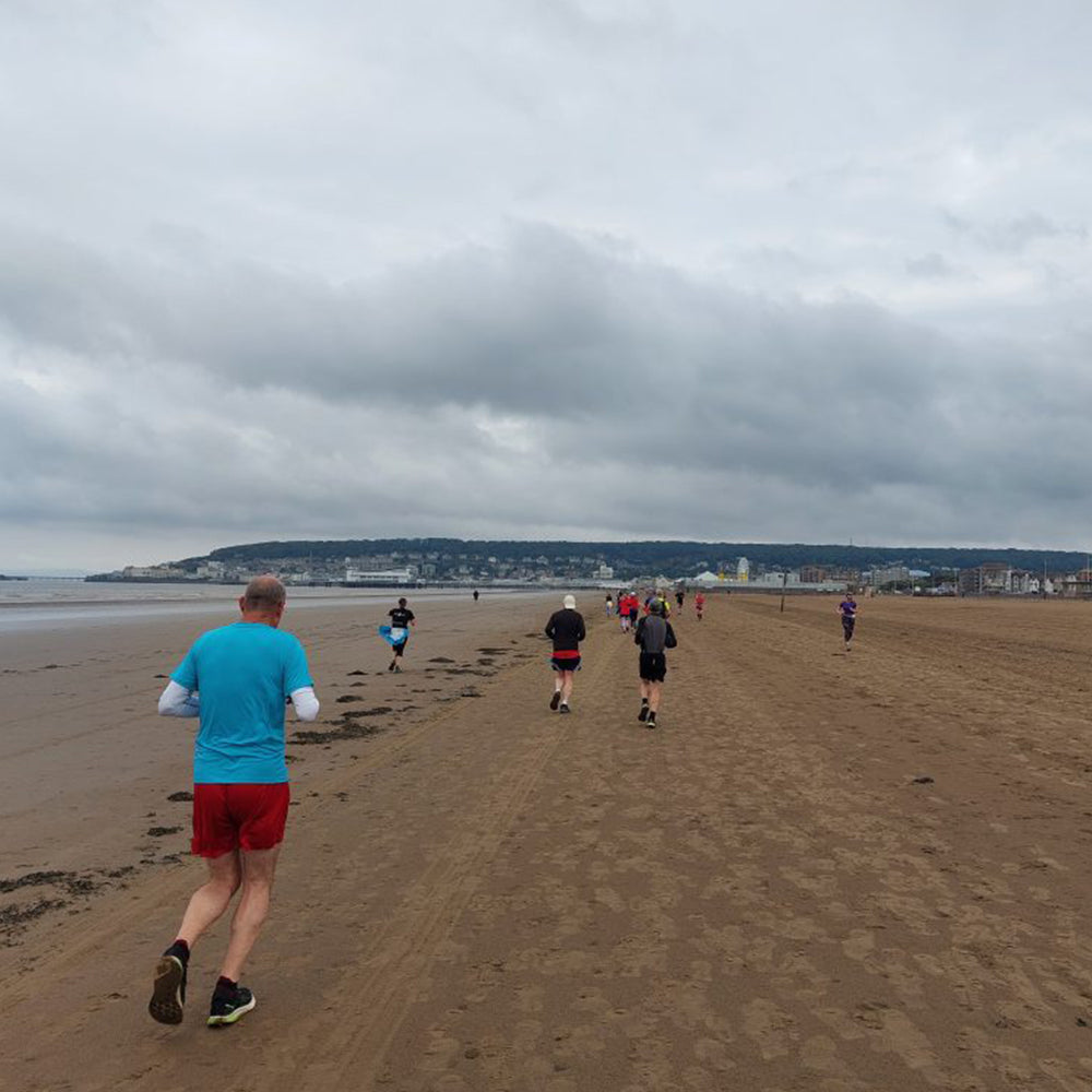Image of runners taking part in Marine Parade Parkrun on a sandy beach
