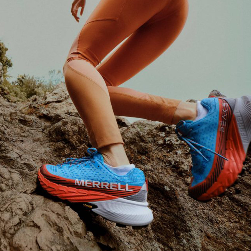 Photograph of someone running on a rocky trail wearing Merrell trail running shoes